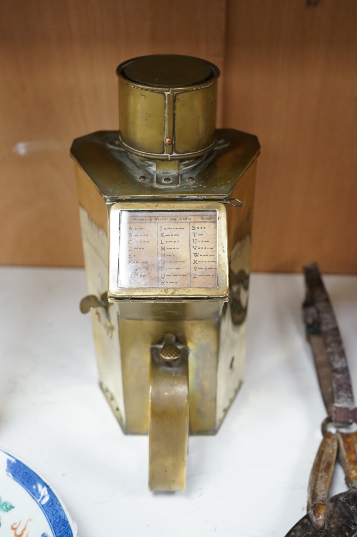 A naval brass Mitchell’s Patent morse code signalling lamp, numbered 24014 and dated 30 10 07, triangular body engraved ‘HMS Dreadnought’ to one face and ‘Admiral’s Barge’ to another, complete with burner and morse code